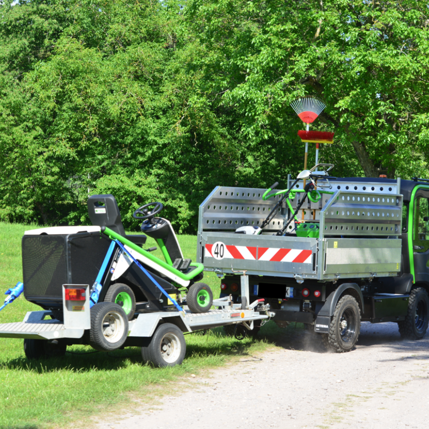 et lander towing a ride-on mower