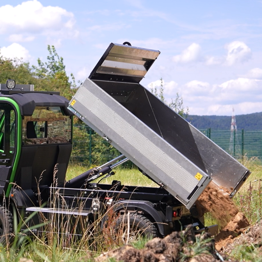 long tipper in unloading mode, filled with earth